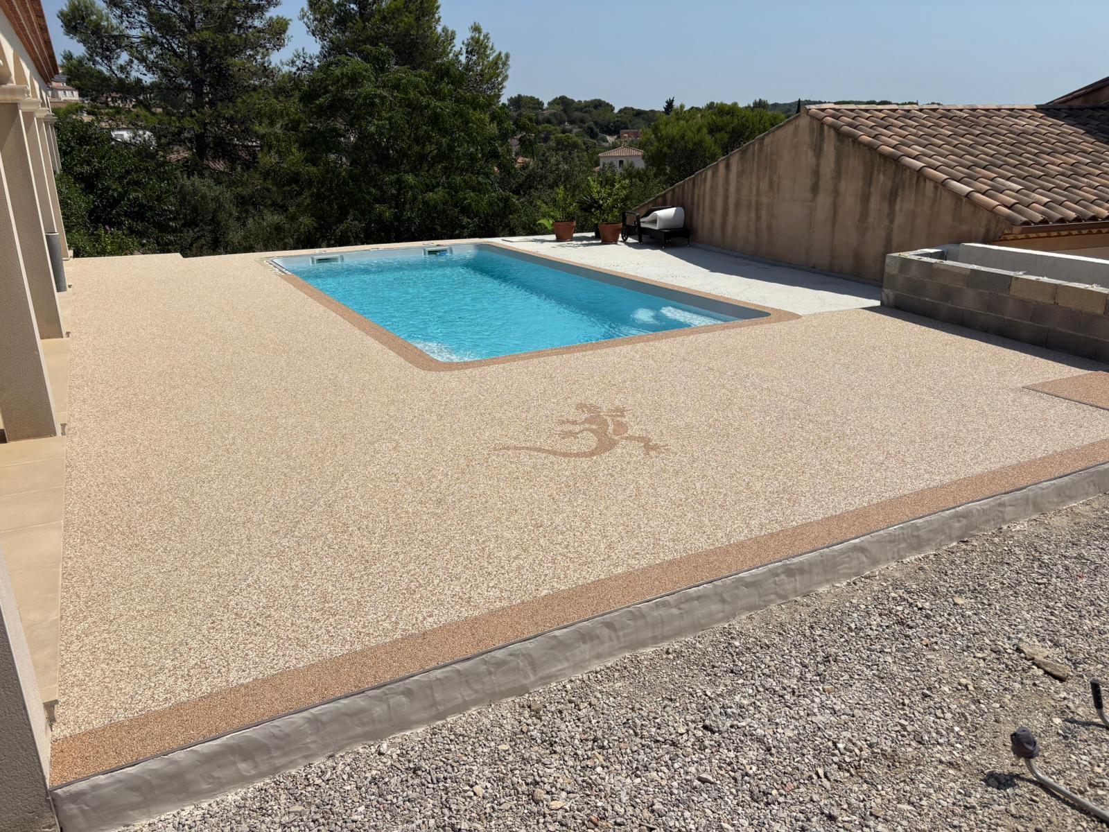 Plage de piscine en granulat de marbre beige avec motif lézard